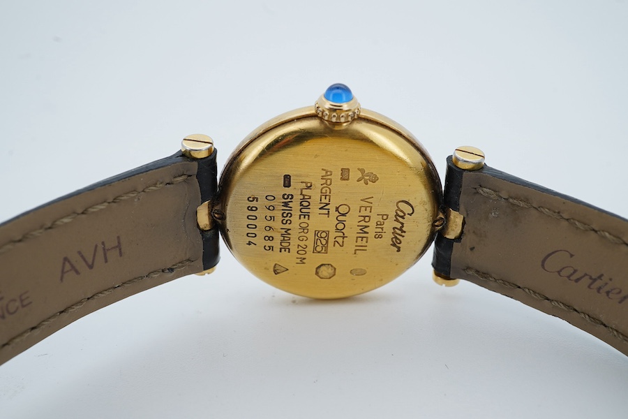 A lady's modern gilt 925 Must de Cartier quartz wrist watch, with circular Roman dial and cabochon set winding crown, case diameter 24mm, no box or papers. Condition - not running otherwise fair